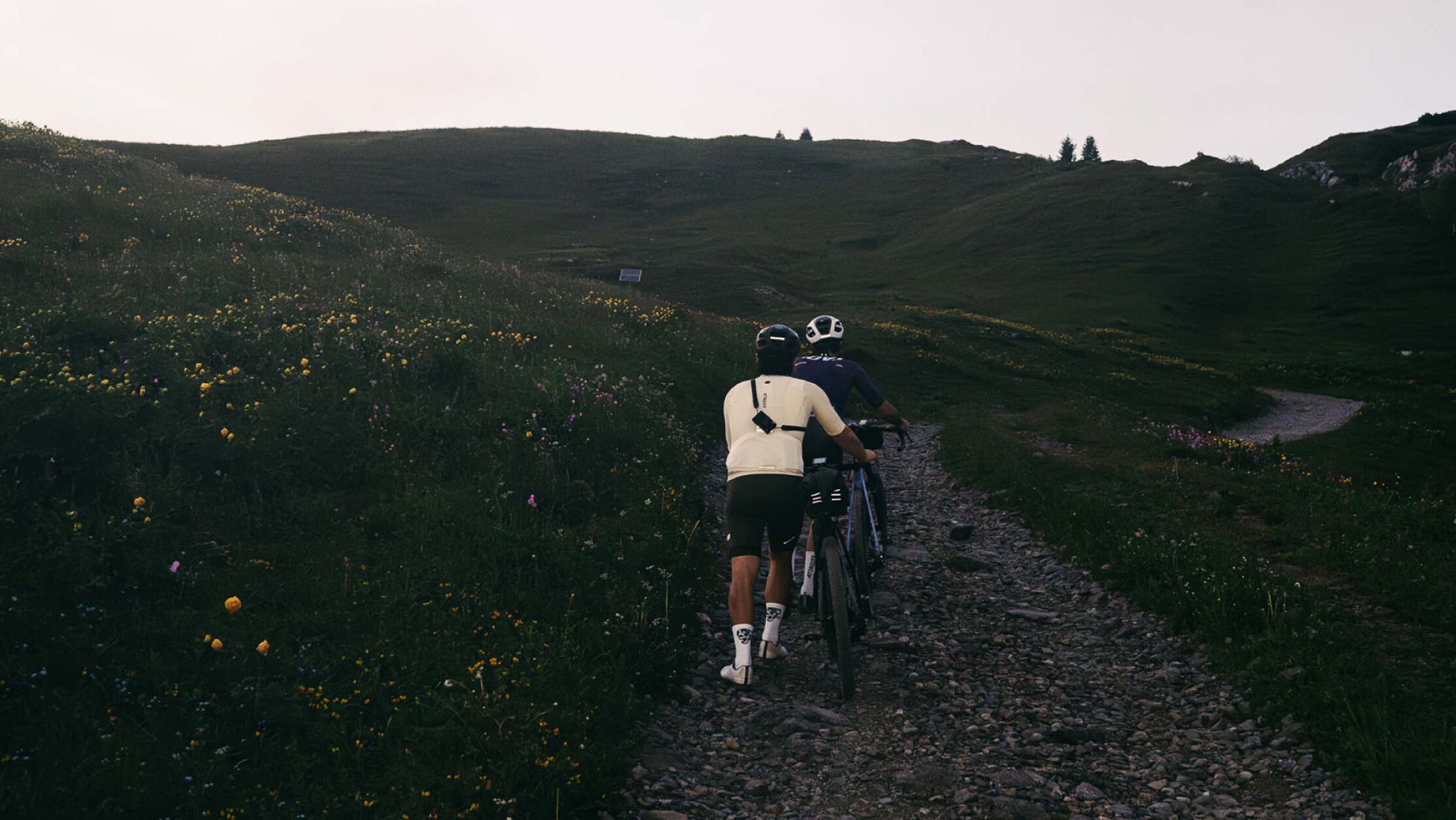 Cyklista na gravel kole s namontovan&yacute;m př&iacute;slu&scaron;enstv&iacute;m na pra&scaron;n&eacute; stezce, kter&yacute; přehledně ukazuje vybaven&iacute; pro ter&eacute;nn&iacute; dobrodružstv&iacute;